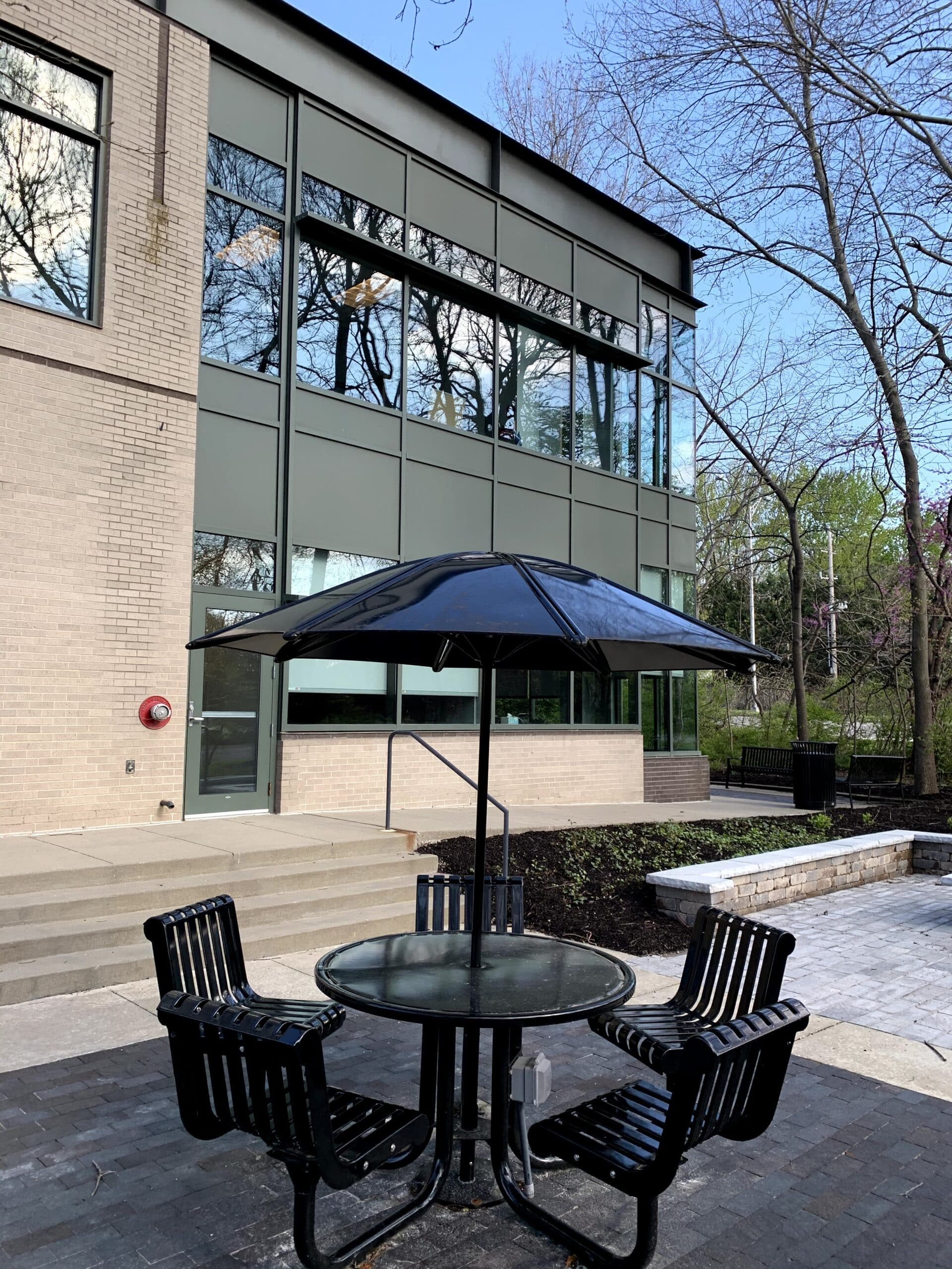 An outdoor patio area with a black table, chairs, and umbrella outside the Three Streams Financial office, where Daniel Gould serves as a financial advisor in Overland Park, KS.
